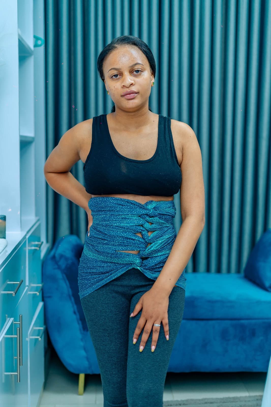 A woman wearing Maggie's teal postpartum belly binder